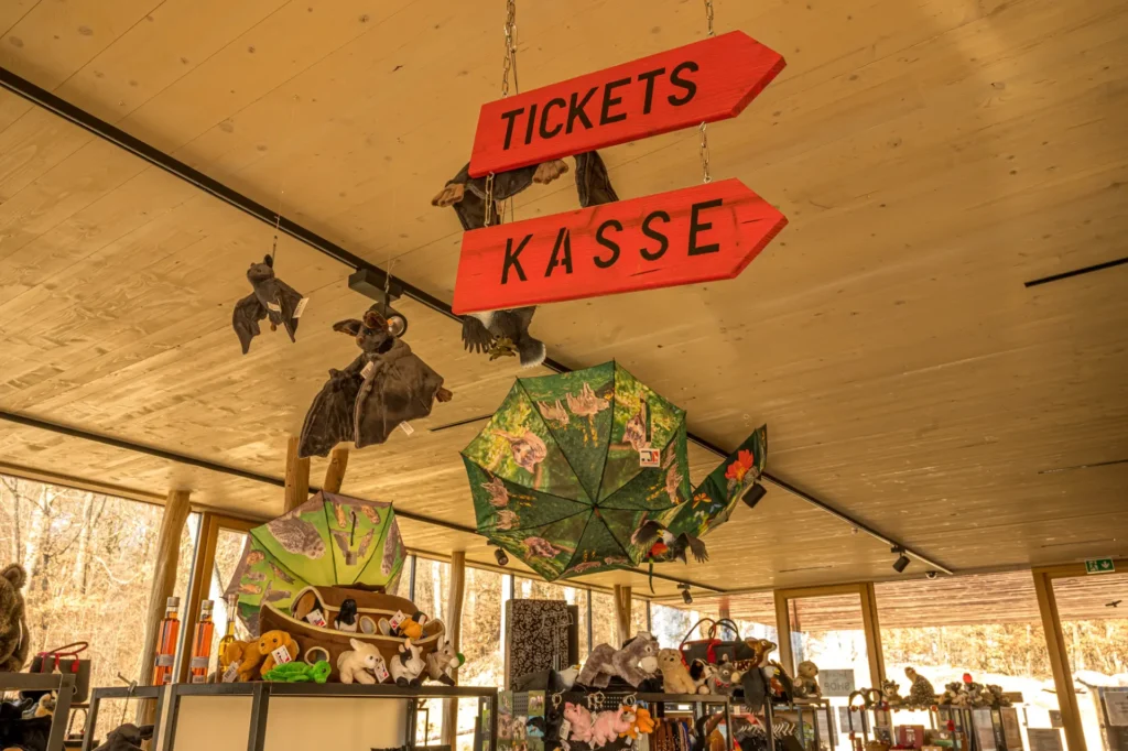 Zwei rote Holzschilder mit Pfeilspitze mit den Beschriftungen Kasse und Tickets