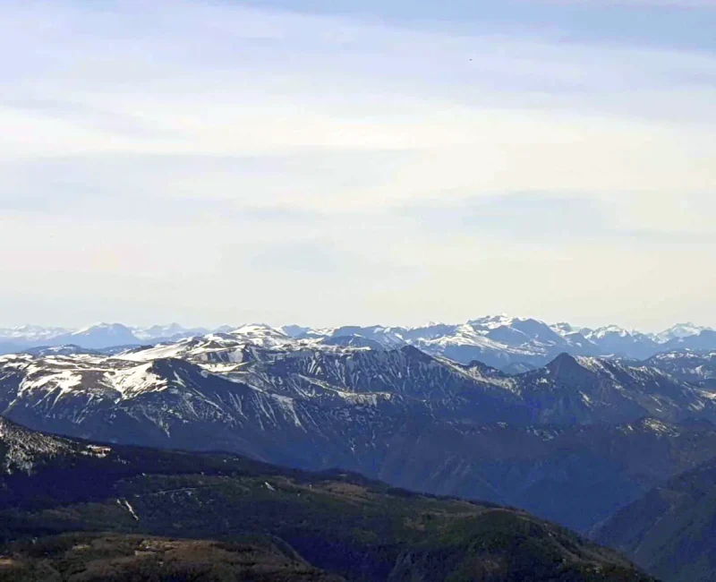 Ein Bild das eine Berglandschaft mit beschneiten Bergspitzen zeigt